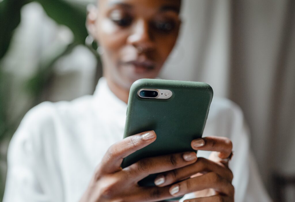 Dame som handler via mobiltelefonen.